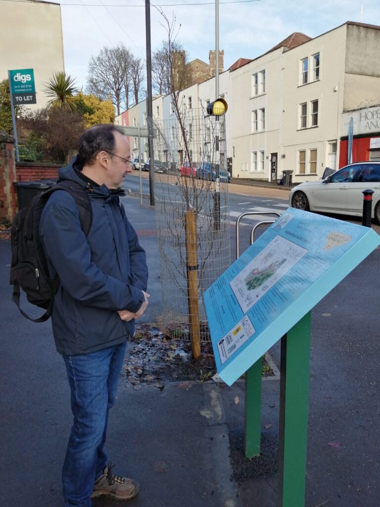 Information board in the street, being viewed by a man