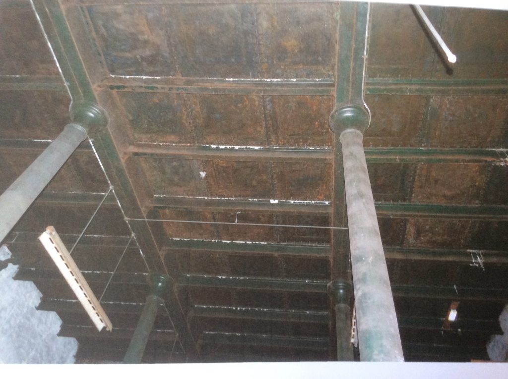 Photo looking up in the boiler house, showing a metal panelled ceiling, supported by pillars